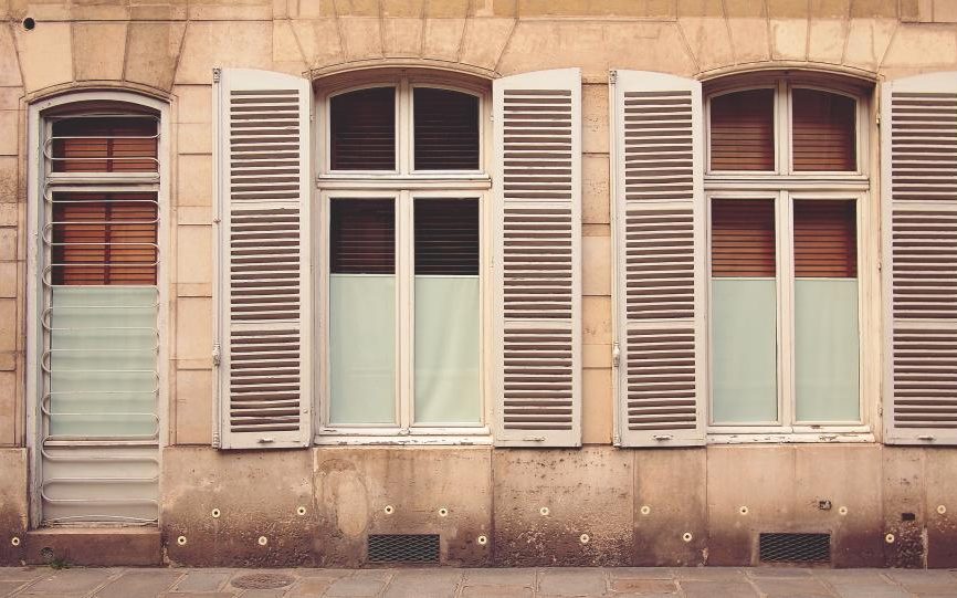 Façade en pierre aux volets clairs