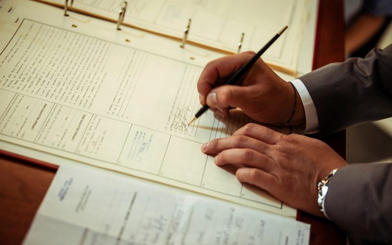 Homme remplissant un document au stylo